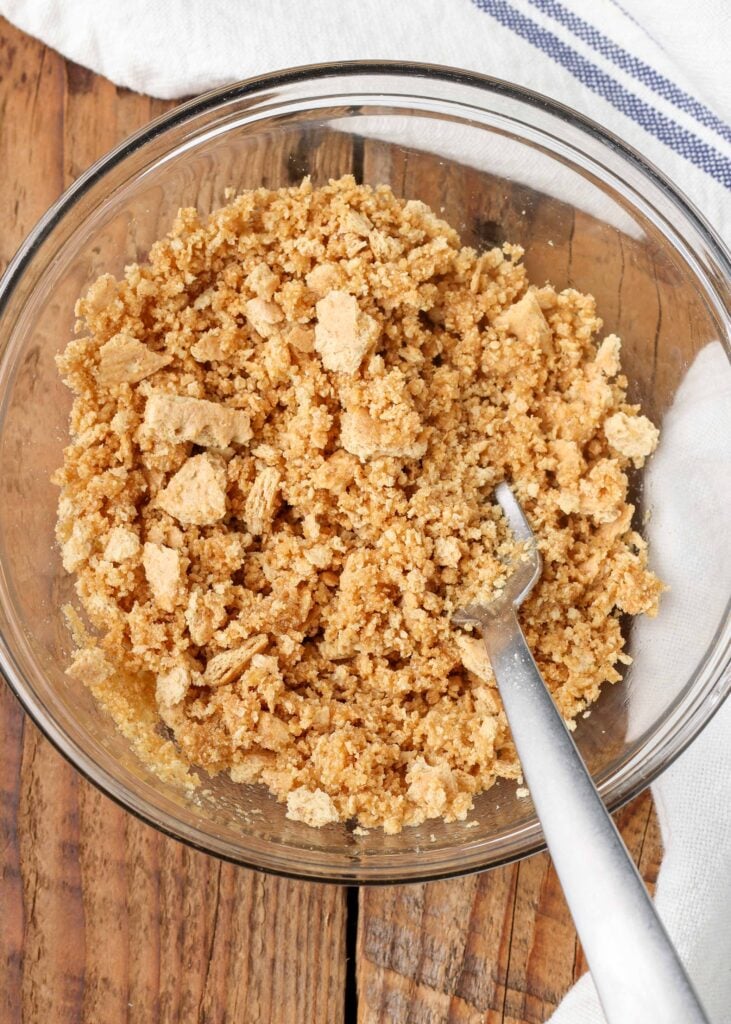 Butter, brown sugar, and graham cracker crumbs in glass bowl