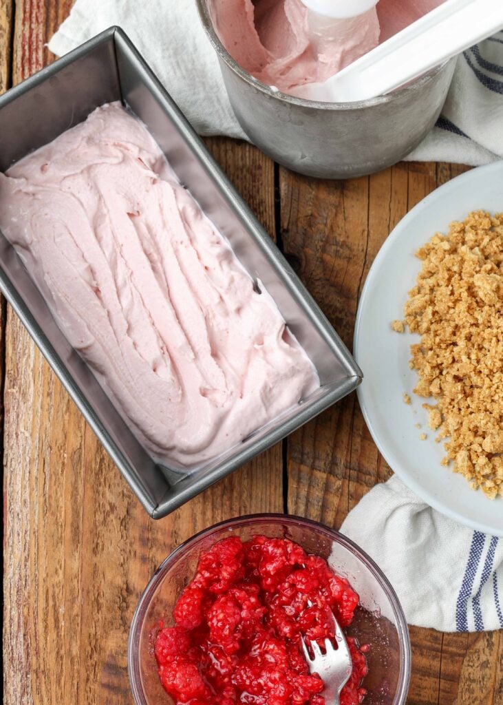 Ice cream, graham cracker topping, and raspberry mix-in prepped to combine