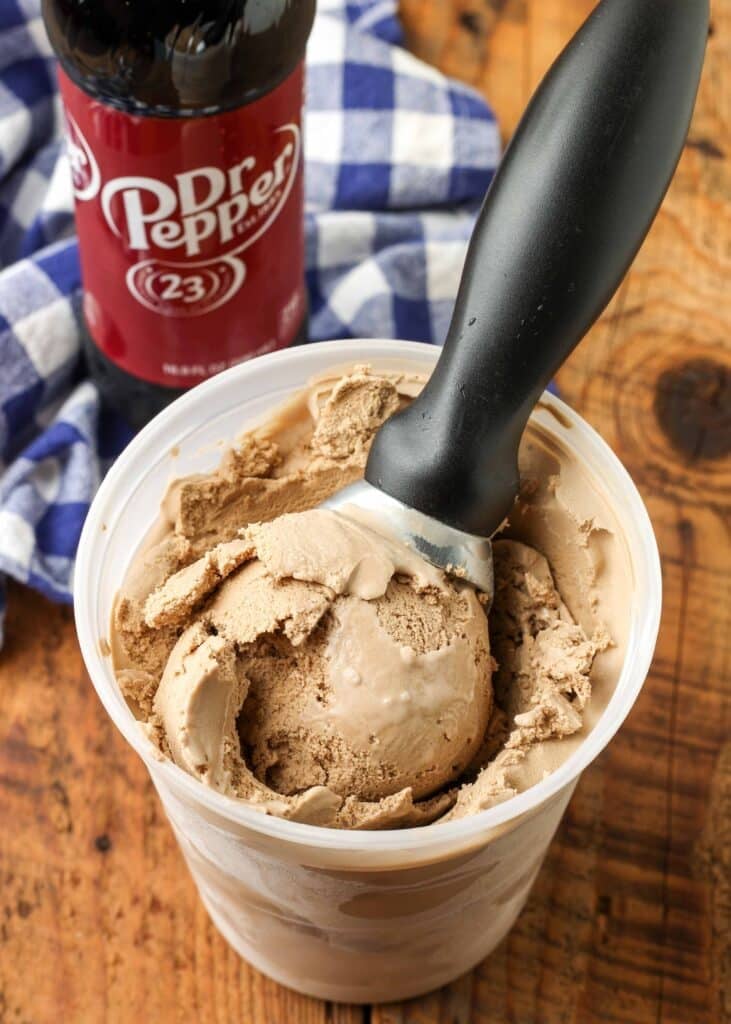 ice cream scoop in container of ice cream next to dr pepper bottle