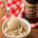 root beer ice cream scooped into a bowl with a 2 liter bottle of root beer nearby