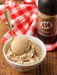 root beer ice cream scooped into a bowl with a 2 liter bottle of root beer nearby