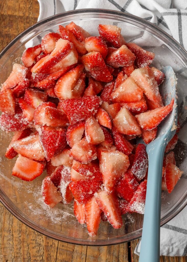 sliced fresh strawberries being mixed with sugar and cornstarch