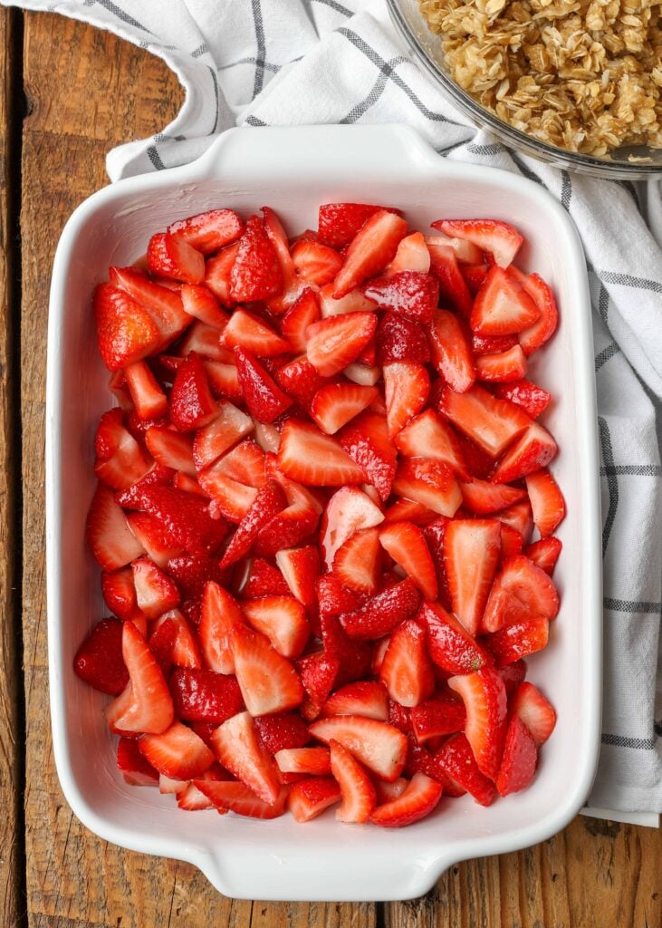 fresh strawberries in the bottom of a white ceramic pan