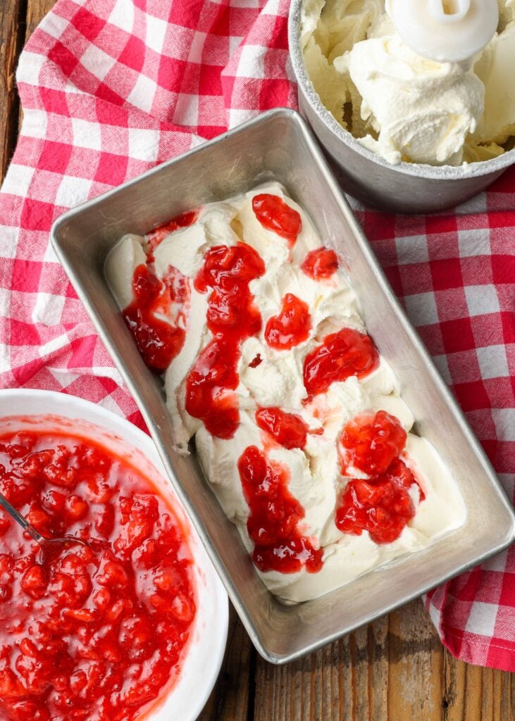 lemonade ice cream in a bread pan swirled with strawberry sauce