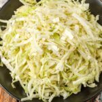 vinegar coleslaw in black bowl over wooden table