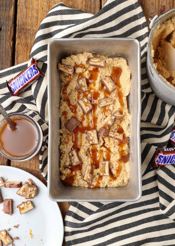 peanut butter ice cream with chunks of snickers candy bars and a caramel swirl