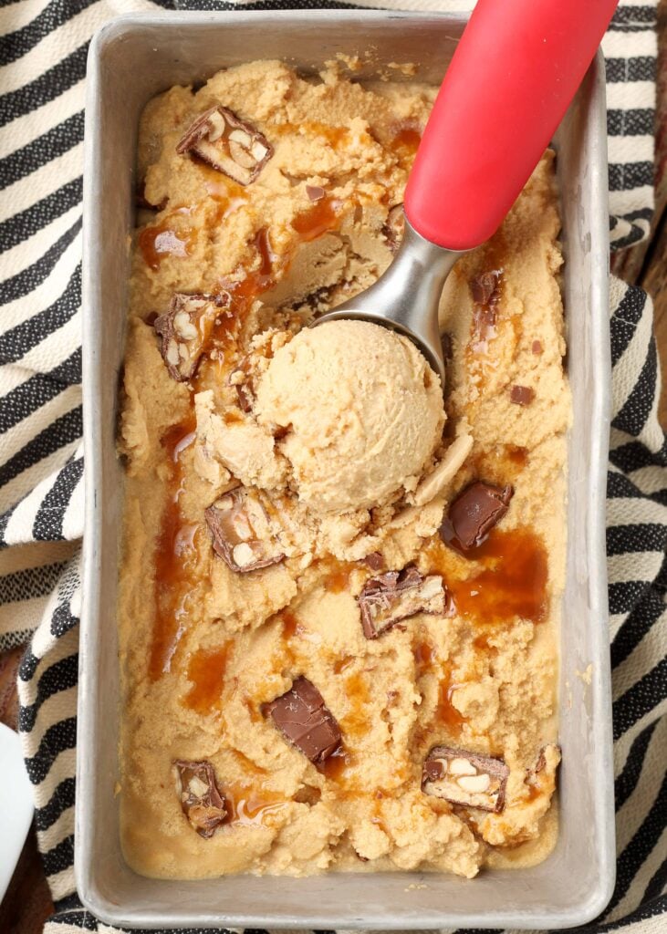 peanut butter ice cream with chunks of snickers candy bars and a caramel swirl