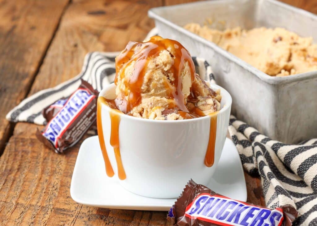 peanut butter ice cream with chunks of snickers candy bars and a caramel swirl