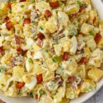 Overhead shot of creamy potato salad in white bowl