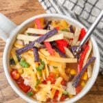 A vertically aligned photo of a top down image of a mug of chicken soup.