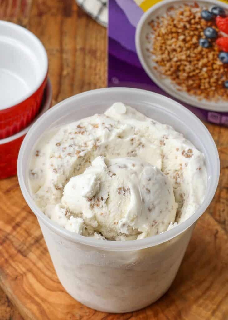 vanilla ice cream with grape nuts in clear container next to cereal box