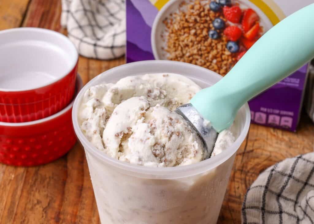 vanilla ice cream with grape nuts mixed throughout in container with scoop