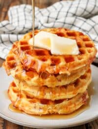 Bacon cheddar cornbread waffles topped with butter and syrup