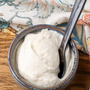 A vertically aligned image of a scoop of horchata ice cream in a small bowl on a wooden tabletop