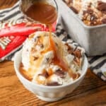 A vertically aligned image of an action shot, drizzling caramel sauce over a small bowl of ice cream.