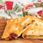 Two wedges of a bacon quesadilla in a close up shot