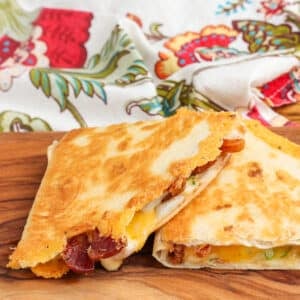 Two wedges of a bacon quesadilla in a close up shot