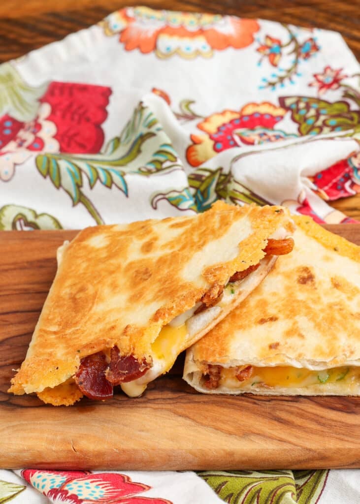 Two wedges of a bacon quesadilla in a close up shot