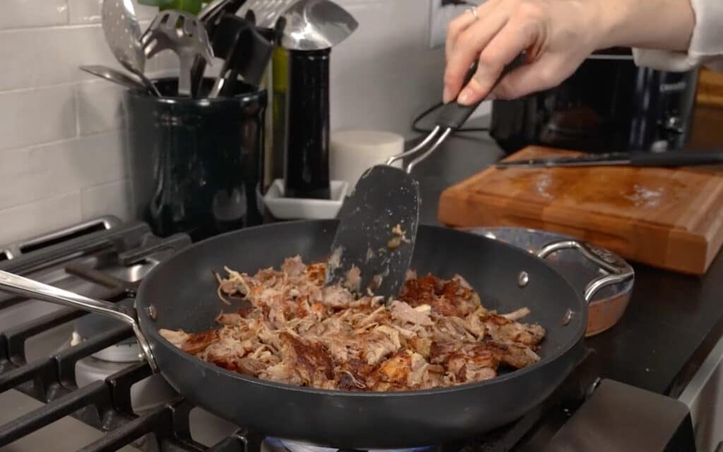 heating and crisping the carnita meat in the skillet