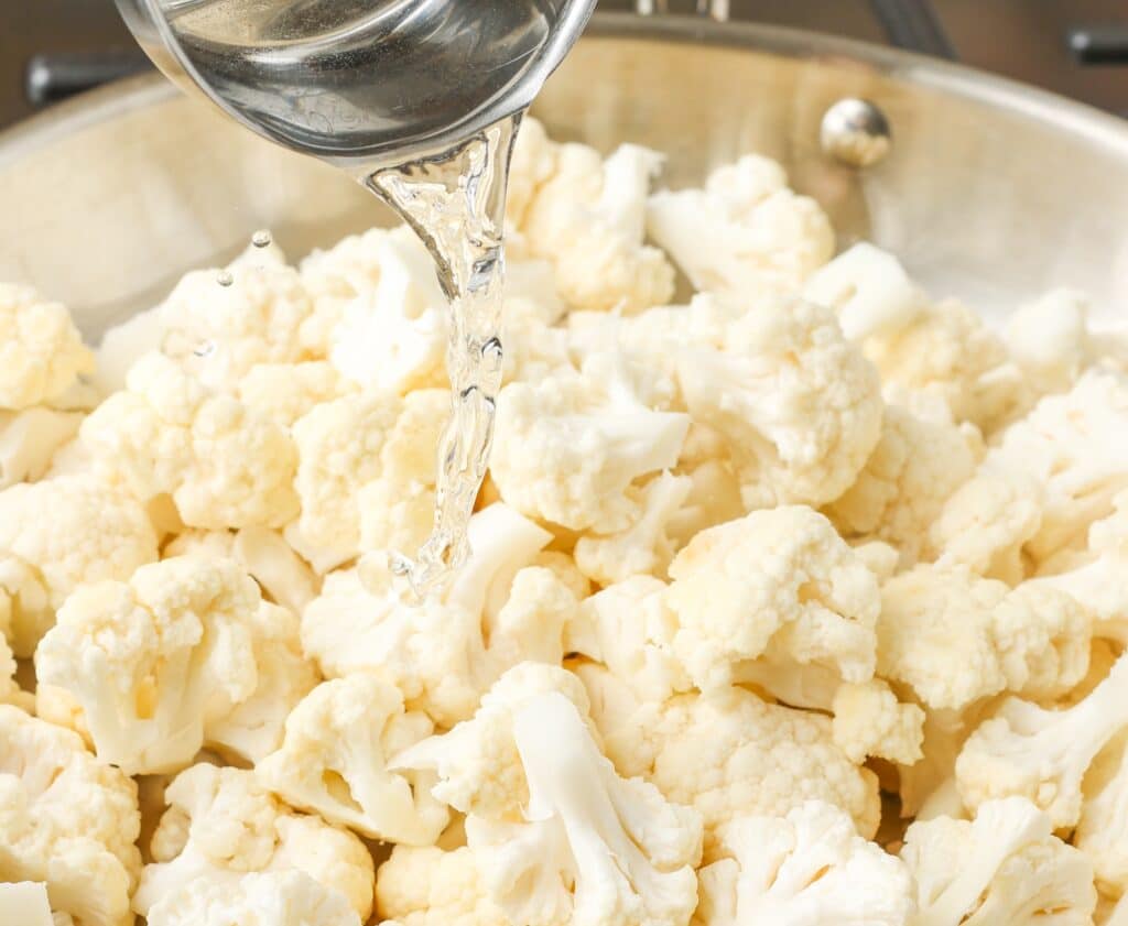 adding splash of water to sauteeing cauliflower