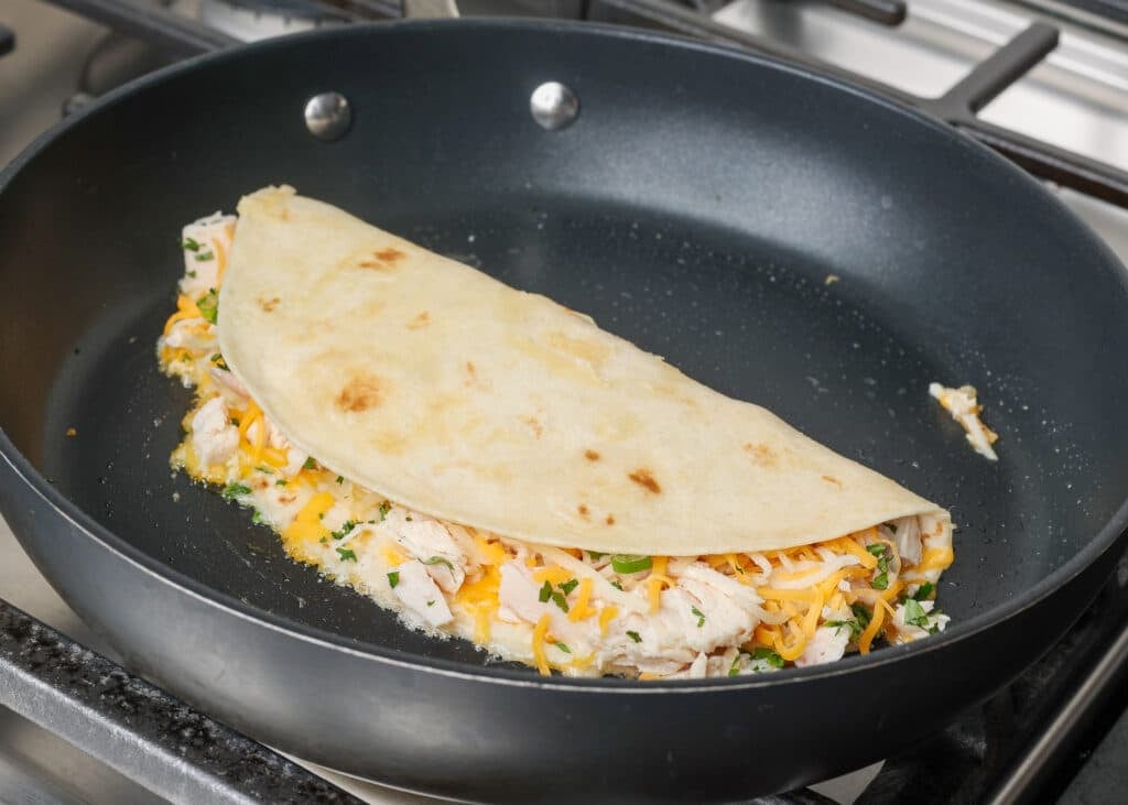 folded chicken quesadilla in skillet