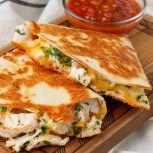 close up of chicken quesadilla on board with salsa