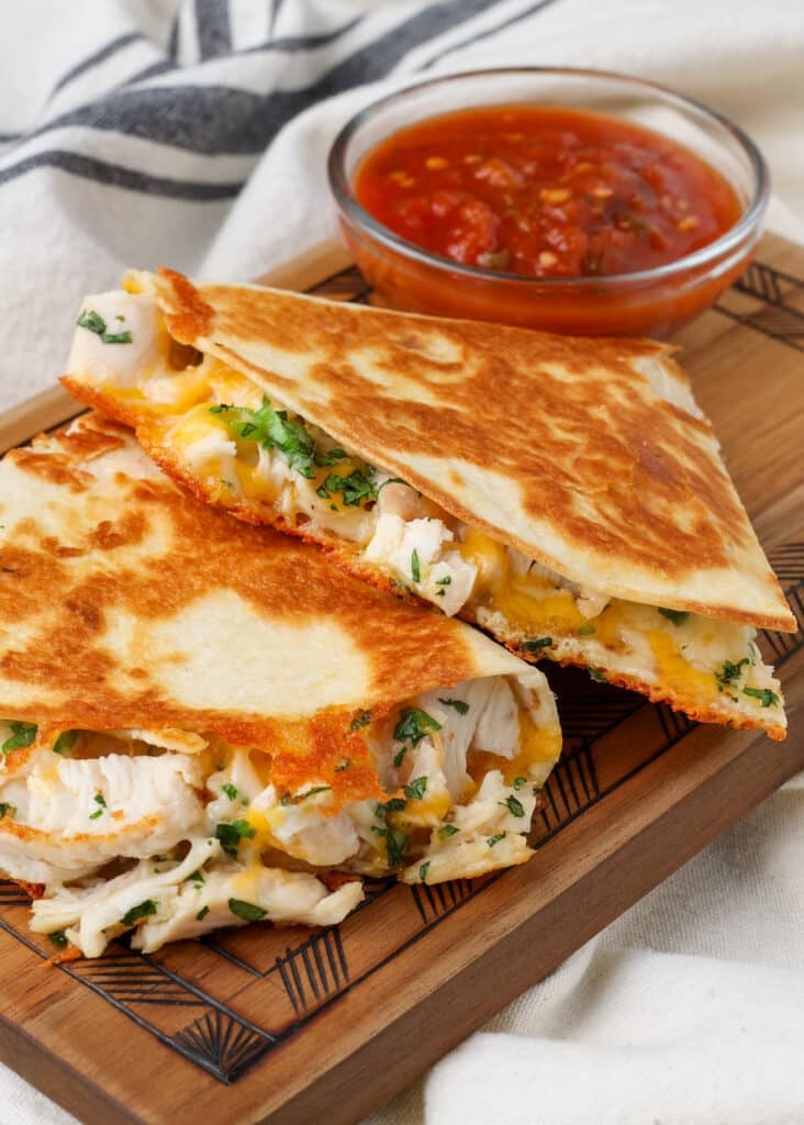 close up of chicken quesadilla on board with salsa