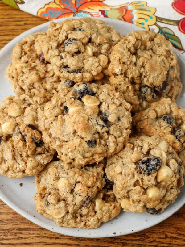 plate of stacked cranberry white chocolate chip cookies on table