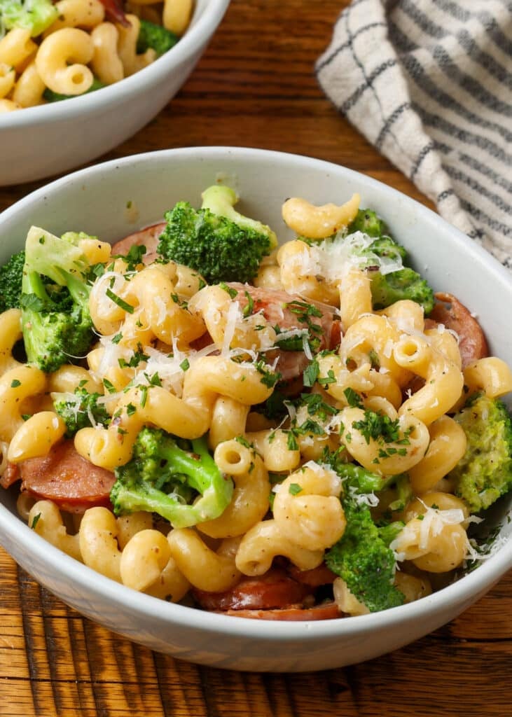 closeup of pasta with kielbasa and broccoli on wooden table
