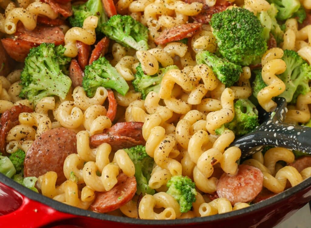 closeup horizontal photo of creamy pasta with broccoli and kielbasa