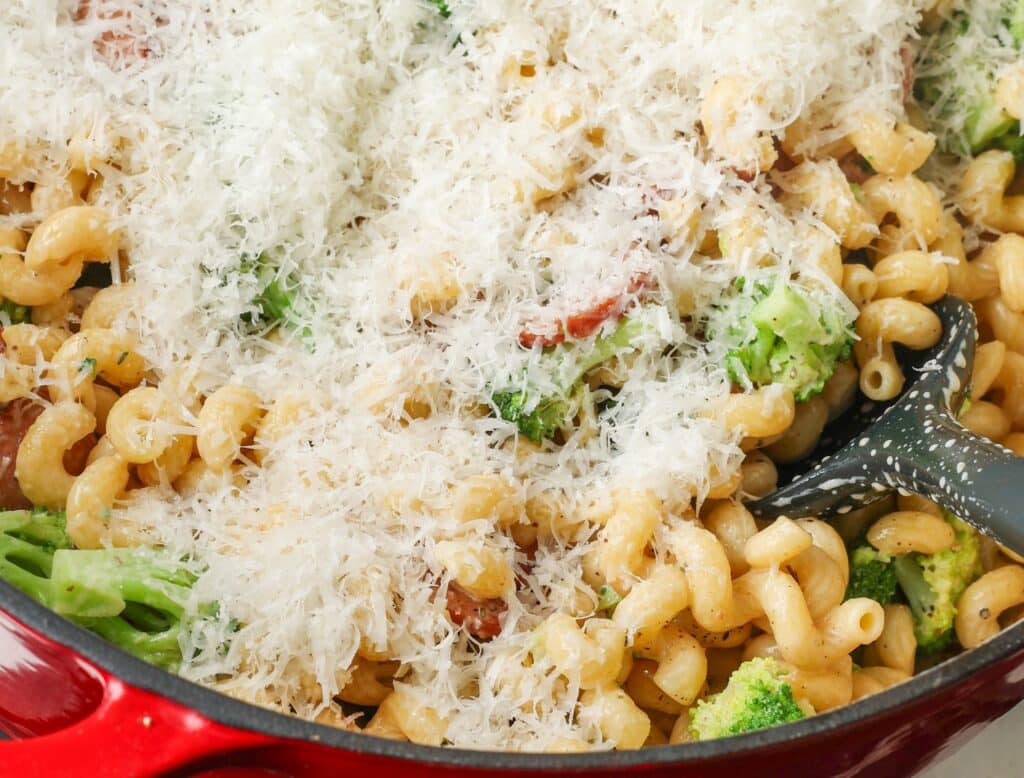 adding cheese to pasta in pot