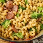 creamy kielbasa pasta with broccoli in red enamel pot on table