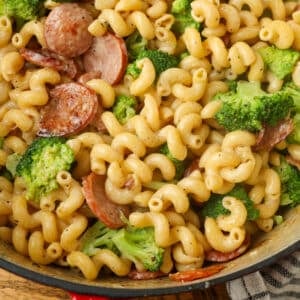 creamy kielbasa pasta with broccoli in red enamel pot on table