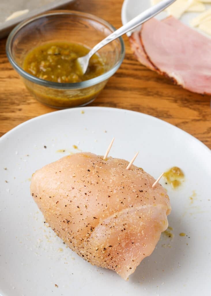 A green chile chicken cordon bleu is pinned, ready for the pan.