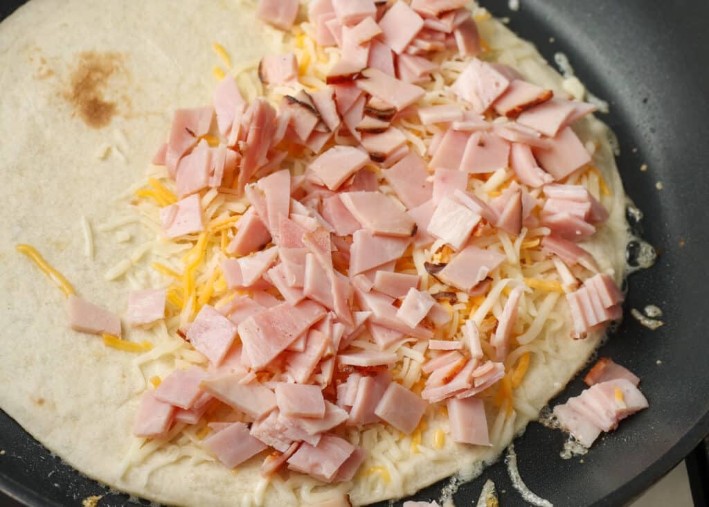 The ham has been layered on top of the cheese in this process shot.