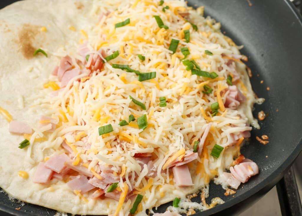 The final layer of cheese has been added on top of the chopped ham in this process shot.