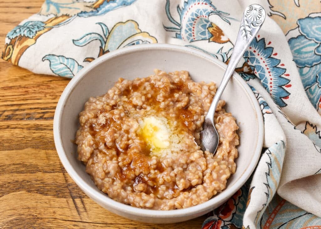 cooked steel cut oats in bowl with butter and brown sugar