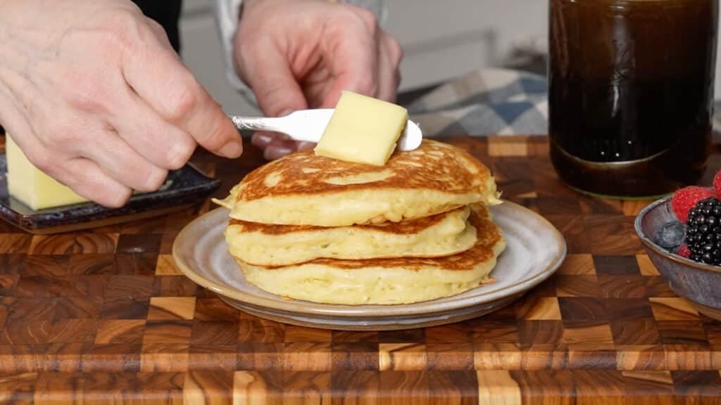 butter on top of stack of pancakes