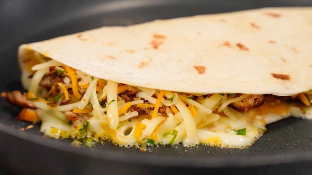 cheese melting in quesadilla in skillet