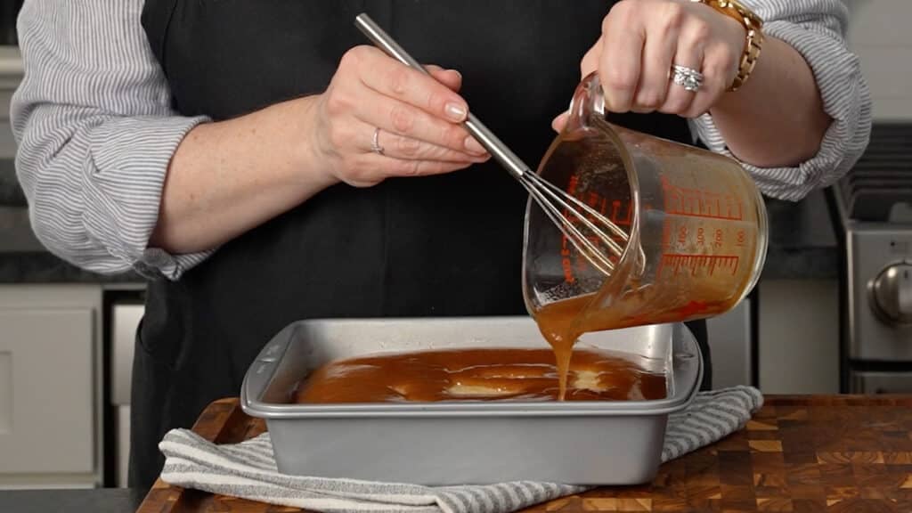pouring cinnamon sugar topping over partially baked cake