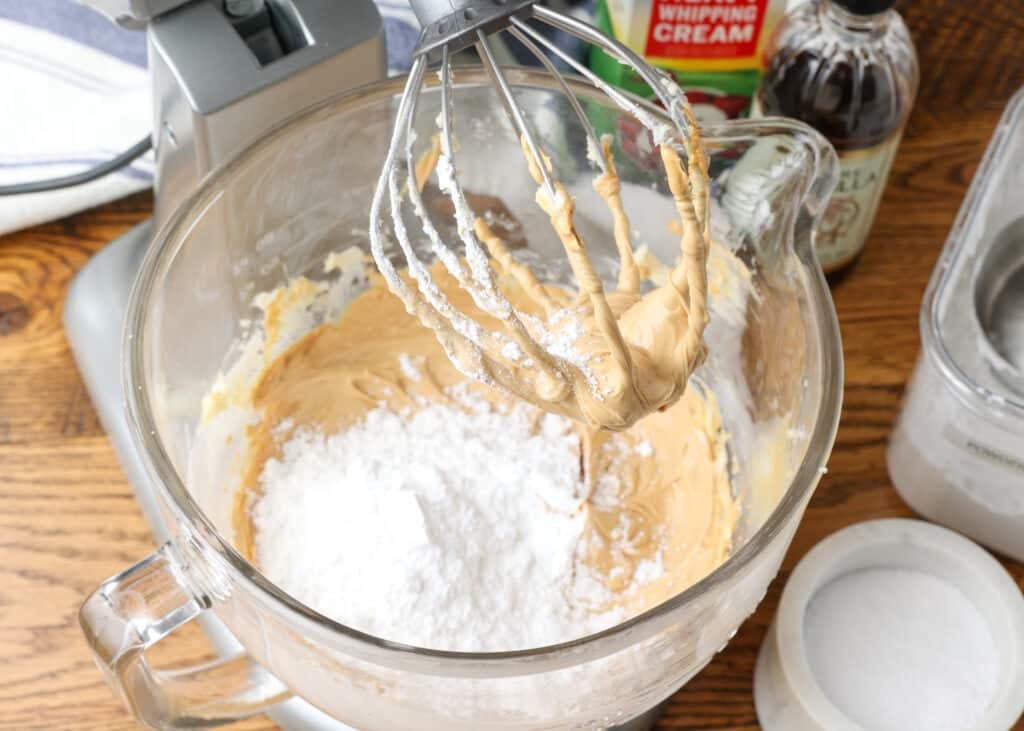 The white powdered sugar has been added to the peanut butter base.