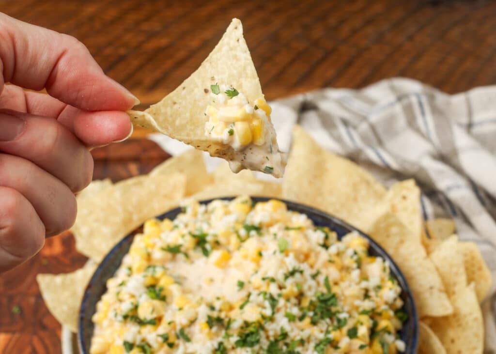 corn dip on a tortilla chip in hand