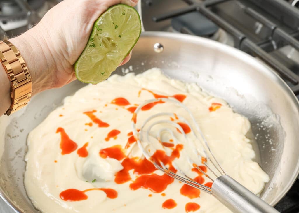 adding the lime juice to the sauce in the skillet