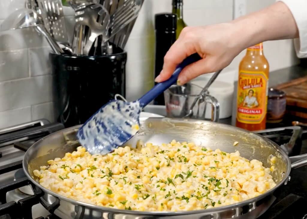adding the corn and cilantro to the skillet