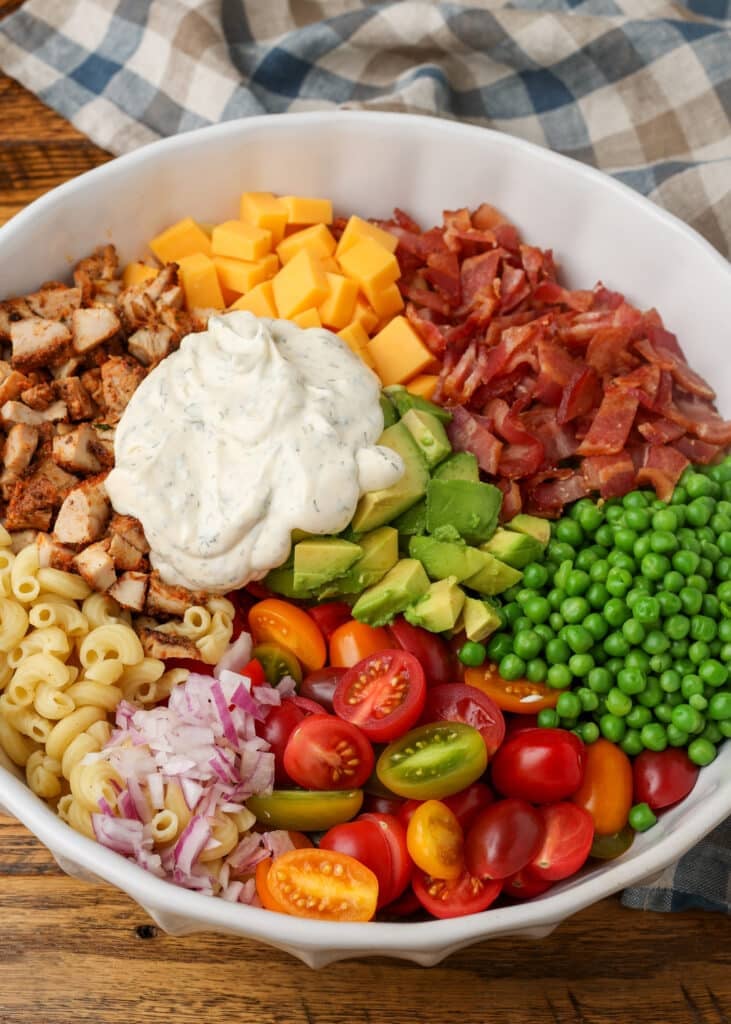 The dressing has been added on top of the other ingredients, and it is ready to mix togehter.