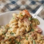 A close up on a metal spoon full of Chicken Bacon Ranch Pasta Salad in the foreground.