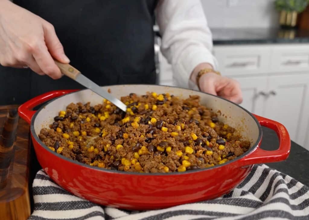 taco beef with corn and black beans in red skillet