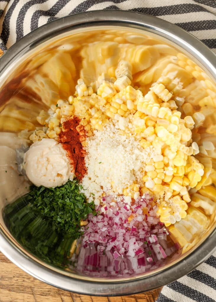 ingredients for elote dip in stainless mixing bowl