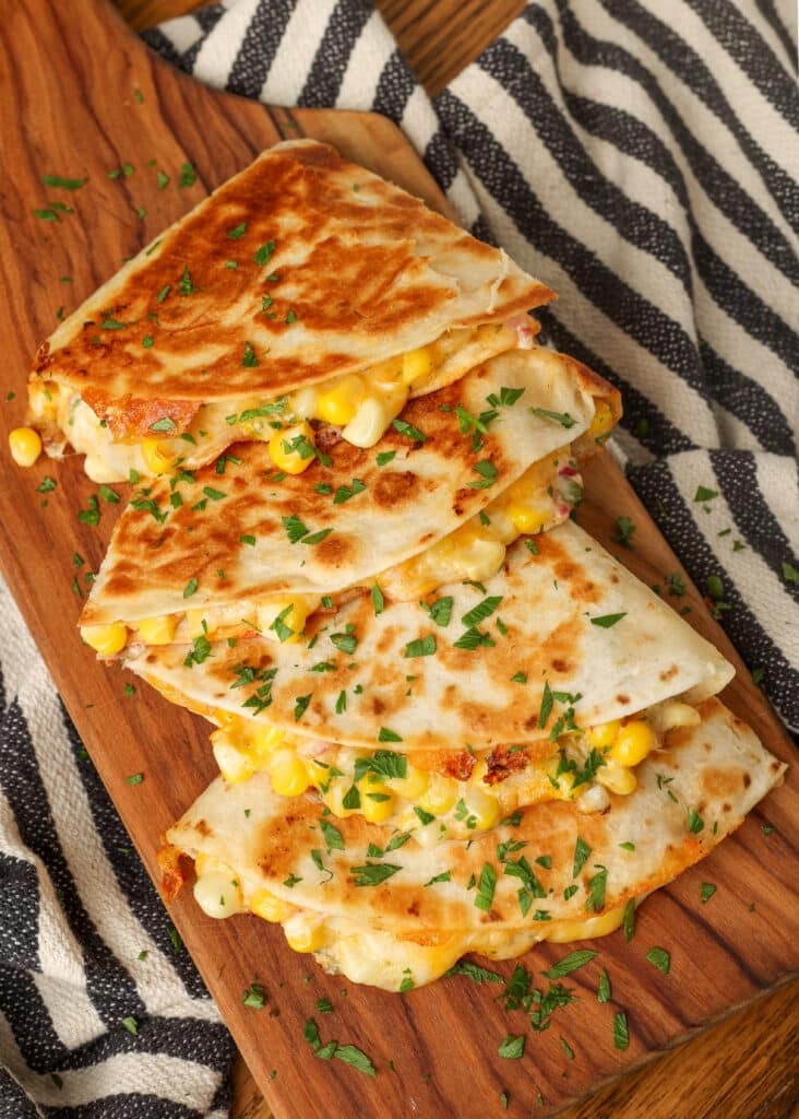 stacked quesadillas on board, filled with corn