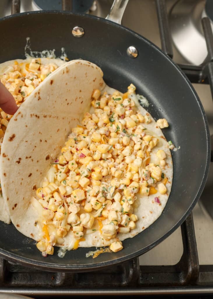corn filling inside tortilla in skillet